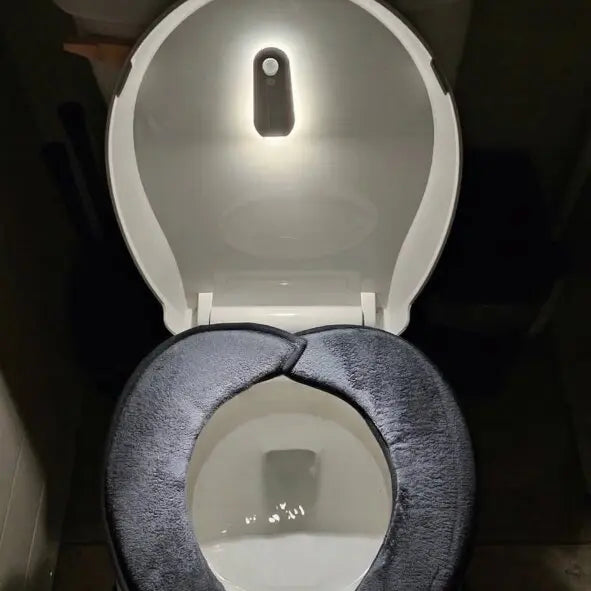 Smart toilet seat with built-in night light and plush cover, illuminated for nighttime use
