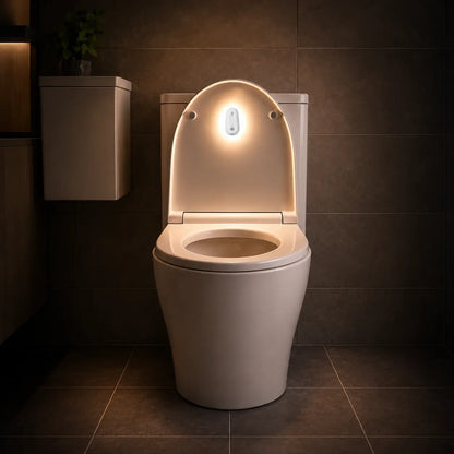 Smart toilet seat with motion-activated night light illuminating bathroom, warm glow for safety and convenience