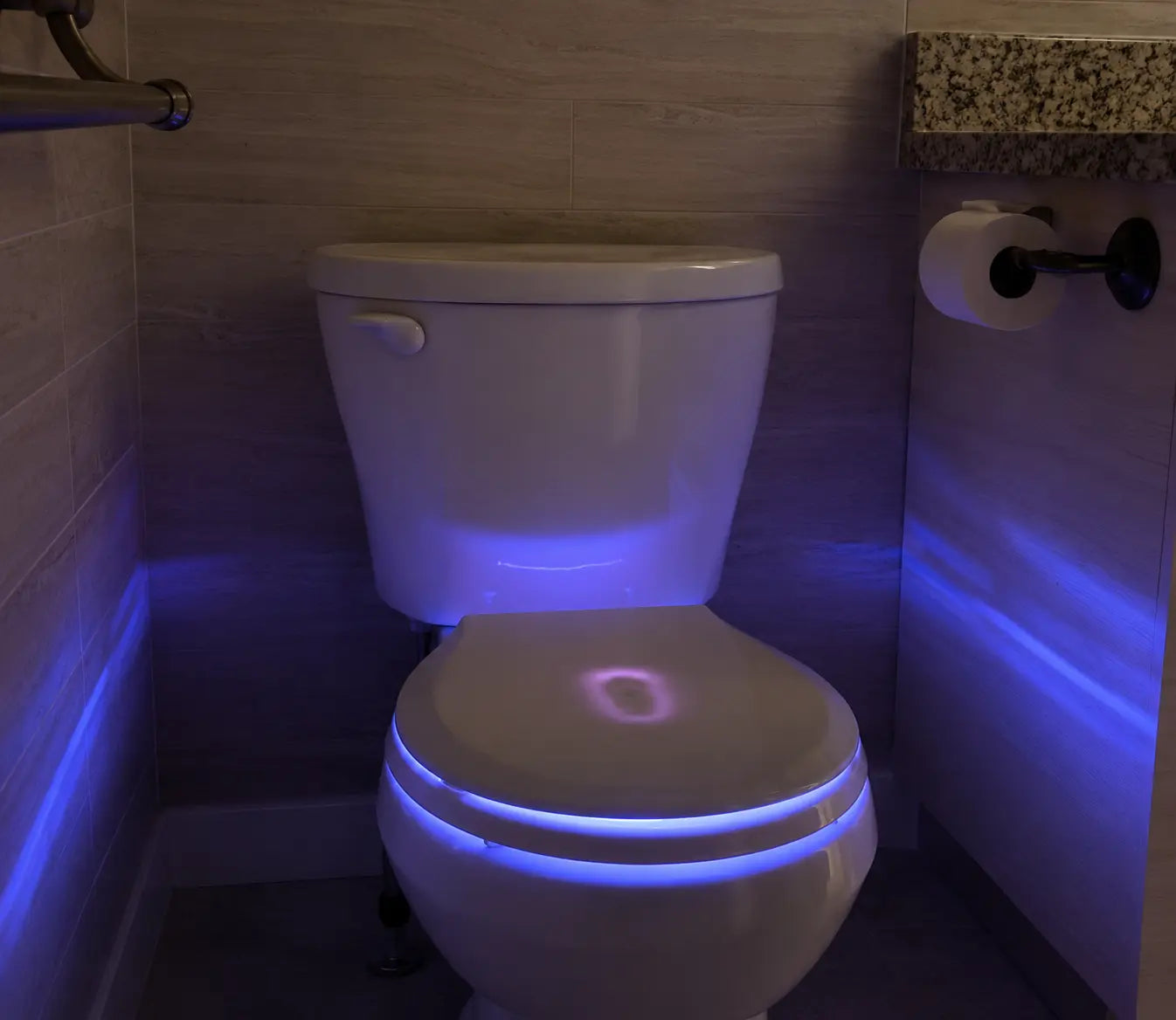 Smart toilet with blue LED night light illuminating bowl and seat in modern bathroom