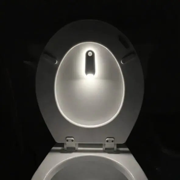 Smart toilet night light illuminating bowl in dark bathroom, motion-activated LED glow for safety